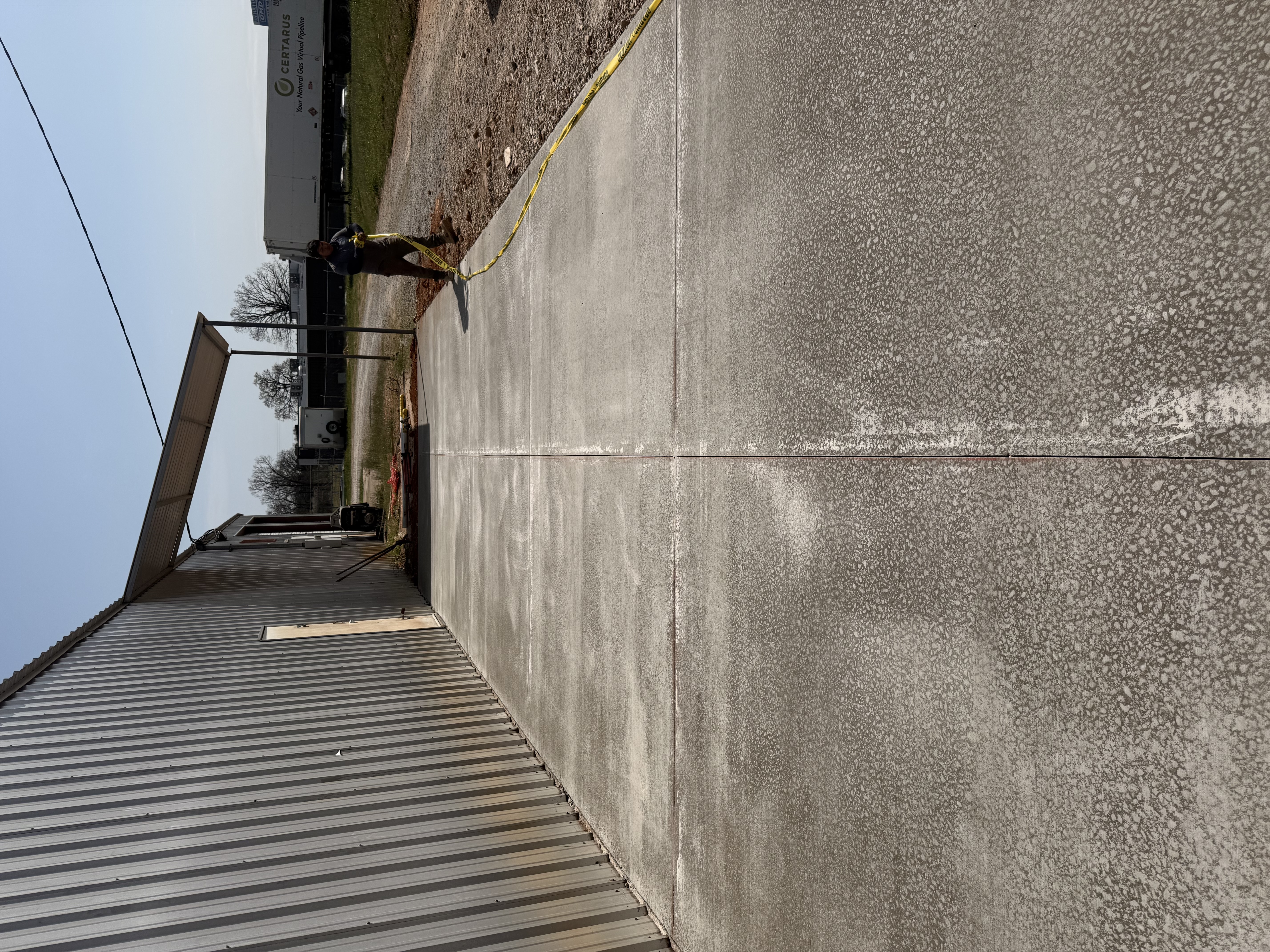 Concrete apron extension with metal awning at commercial building